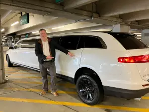 a driver stays near to the limousine